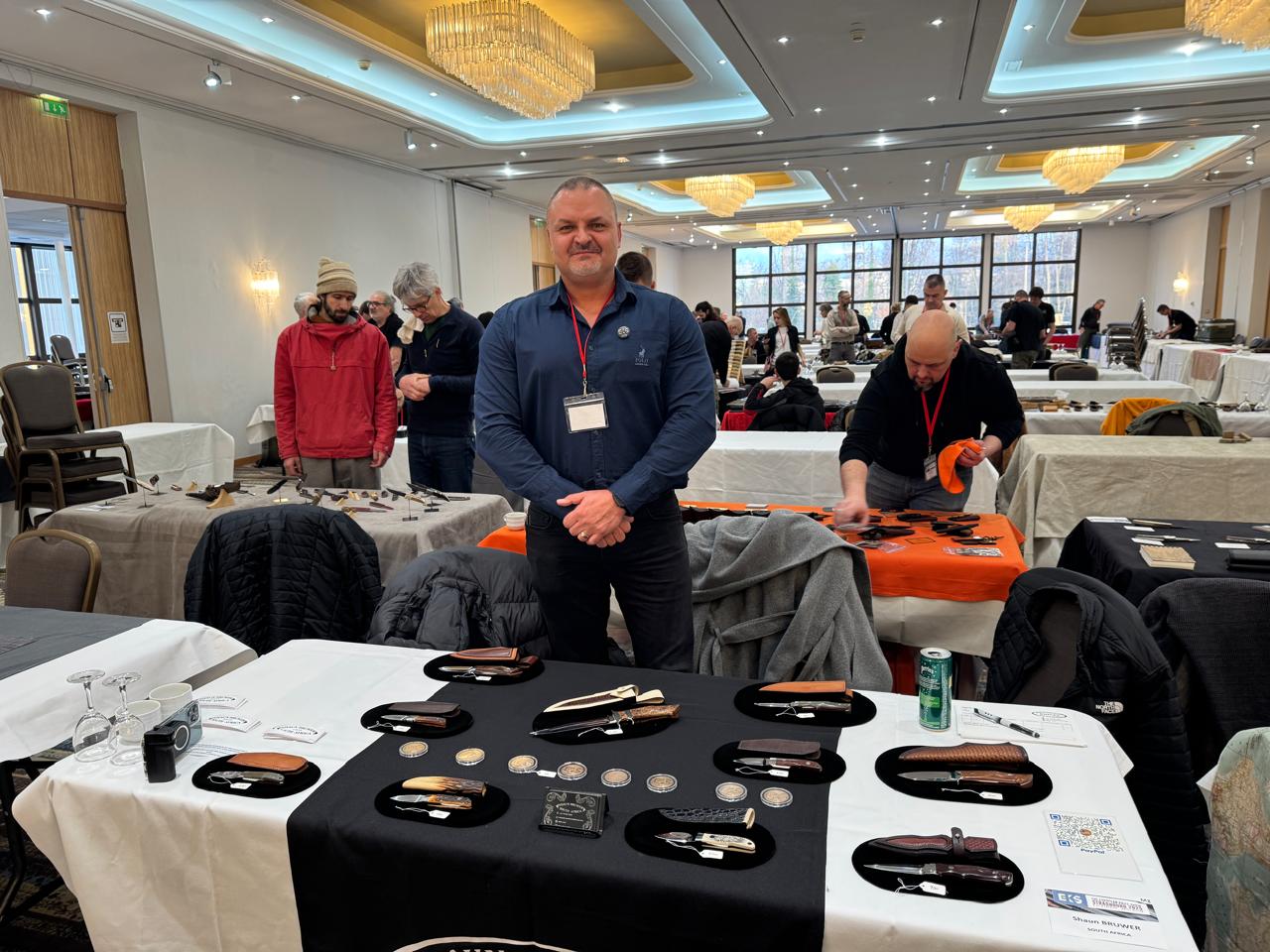 Shaun Bruwer showcasing handcrafted Loveless-style knives at a knife show